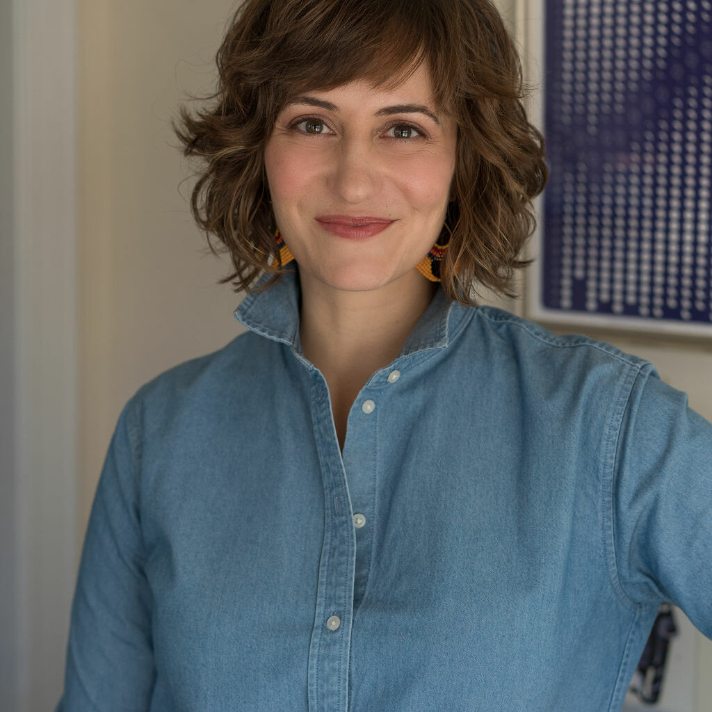 042Paige_2019-Edit Marketer Paige Worthy stands confidently with a smile on her face, looking directly into the camera. Her office is blurred in the background.